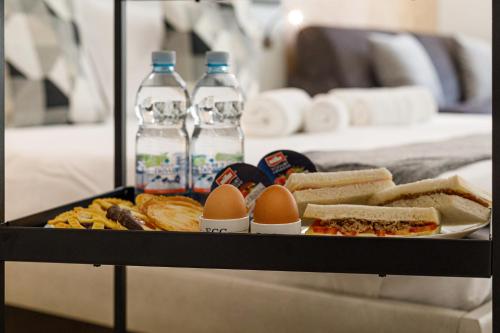 a tray of eggs and sandwiches and bottles of water at Erreggi Luxury Rooms in Rome
