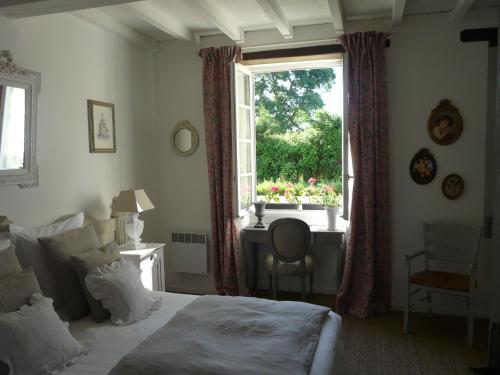 a bedroom with a bed and a window with a desk at La Closeraie Saint Girons in Saint-Girons-dʼAiguevives