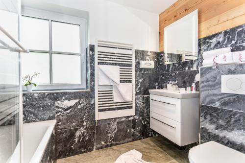 a bathroom with a tub and a sink and a shower at Gasthof Andrelwirt Rauris in Rauris