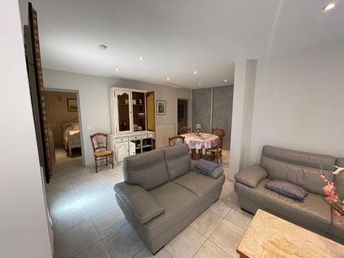 un salon avec un canapé et une table dans l'établissement Petite maison près du centre, à LʼIsle-sur-la-Sorgue