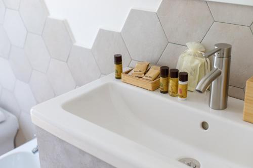 a white bathroom with a sink and a toilet at Erreggi Luxury Rooms in Rome