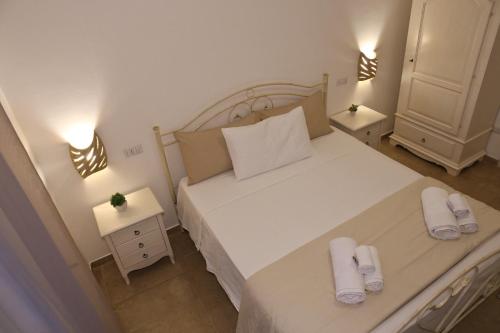 a bedroom with a large white bed with white towels on it at I 7 Peccati in Marina di Mancaversa