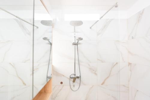 a shower in a bathroom with white tiles at Artistic Tirana Blloku in Tirana