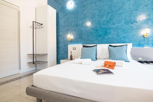 a large white bed in a room with a blue wall at Erreggi Luxury Rooms in Rome