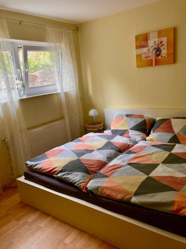a bed with a colorful comforter in a bedroom at Ferienwohnung in Hahnheim, Rheinhessen in Hahnheim