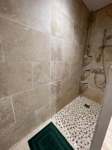 La salle de bains est pourvue d'une douche et d'un mur carrelé. dans l'établissement Petite maison près du centre, à LʼIsle-sur-la-Sorgue