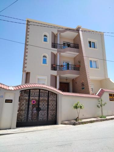 a large white building with a garage at Studio à Hammam Sousse in Hammam Sousse
