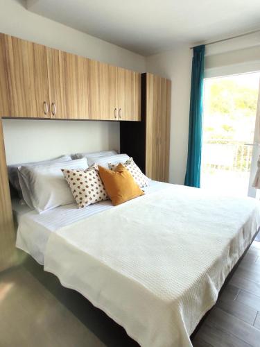 a bedroom with a large white bed with pillows at Apartment Frana DeLux in Kremena