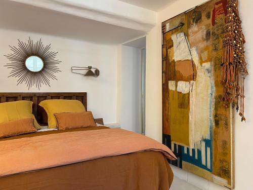 una camera da letto con un letto e uno specchio a parete di LA GASSINIÈRE a Gassin