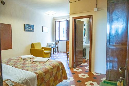 een slaapkamer met een bed en een stoel in een kamer bij casa di Faustina (albergo diffuso) in Corinaldo