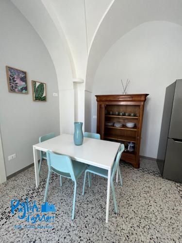 a dining room with a white table and blue chairs at Puglia d'aMare Casa Vacanza in Lizzano