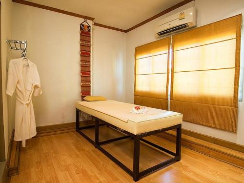 a room with a table and a robe hanging on a wall at Satit Grand View Hotel in Sadao
