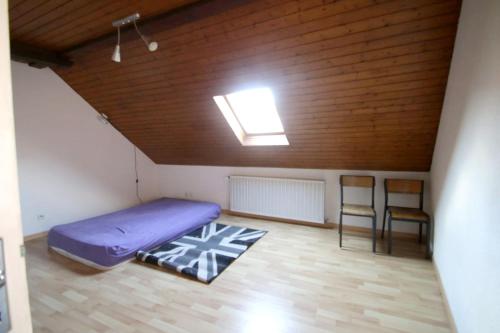 een kamer met een paars bed en 2 stoelen bij Maison de 5 chambres avec wifi a Guebwiller in Guebwiller