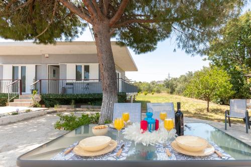 einen Tisch mit Speisen und Getränken vor einem Haus in der Unterkunft Doukas House Cottage with vineyard, Artemis in Artemida