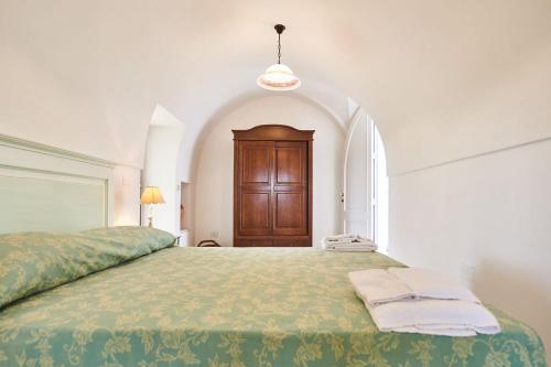 sypialnia z dużym łóżkiem z drewnianymi drzwiami w obiekcie Villa Pompea al piano terra - Apulia Home w mieście Casarano