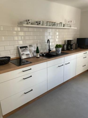 a kitchen with white cabinets and a sink at Ferienwohnung am Elberadweg in Meißen