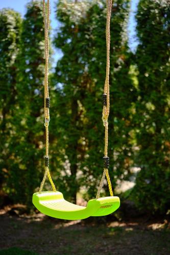 a green swing hanging from a rope at Czarny Kot Mazury Dom Całoroczny in Małkinie