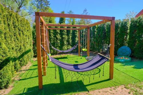 a hammock in the middle of a garden at Czarny Kot Mazury Dom Całoroczny in Małkinie
