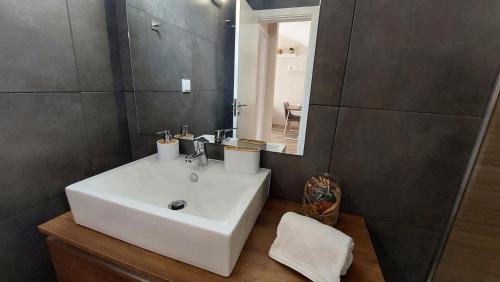 een badkamer met een witte wastafel en een spiegel bij Airport house in Faro