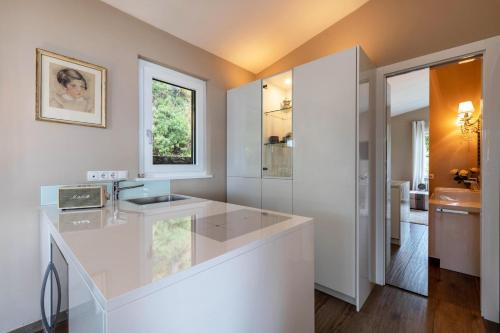 a white bathroom with a sink and a mirror at Ferienwohnung Casa 50 in Gargnano