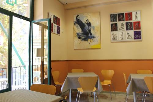 a dining room with tables and chairs and a window at El Jardi in Barcelona