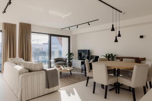 a living room with a table and a dining room at Portwin luxury stays in Knokke-Heist