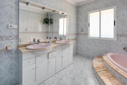 a bathroom with two sinks and a tub at Casa Alicia 10 in Jávea