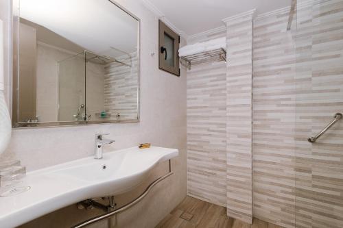 a bathroom with a sink and a shower at Akti Taygetos - Conference Resort in Kalamata