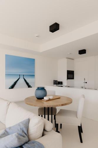 a living room with a table and a couch at Portwin luxury stays in Knokke-Heist