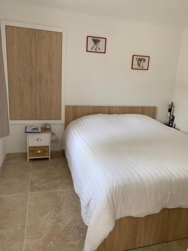 a bedroom with a white bed and a wooden cabinet at Carpe Diem paradise in Mougins