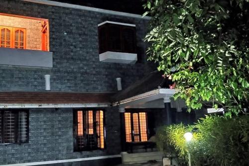 a brick building with windows and a lighted at Anandam Stays - Premium 3BHK plush homestay, Vaikom near Kumarakom in Vaikom