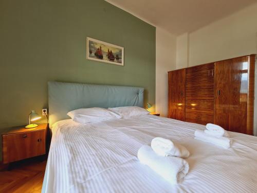 a bedroom with a large white bed with towels on it at Vila Gorenka in Bled