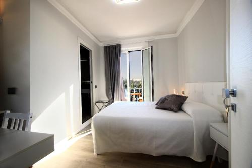 um quarto com uma cama branca e uma grande janela em Affittacamere dei desideri em Numana