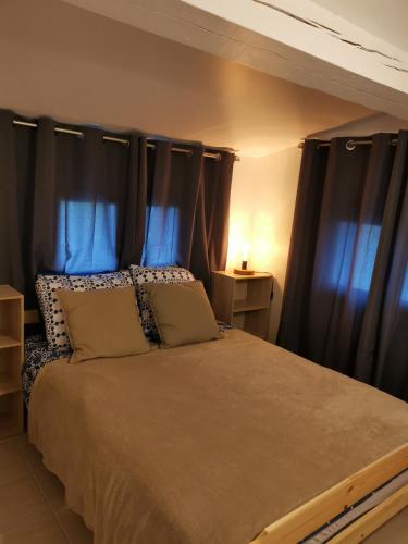 - une chambre avec un grand lit et des rideaux noirs dans l'établissement Mas de Gaussel, à Cabrières