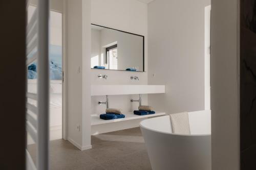 a bathroom with a white sink and a mirror at Portwin luxury stays in Knokke-Heist