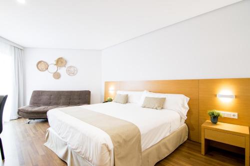 a bedroom with a large white bed and a chair at Cullera Holiday in Cullera