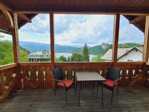 une terrasse couverte avec une table et des chaises et une vue sur le lac. dans l'établissement Vila Gorenka, à Bled