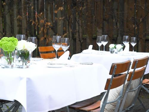 a group of tables with wine glasses and flowers at Hotel Am Park in Leinfelden-Echterdingen