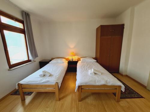two beds in a small room with a window at Vila Gorenka in Bled