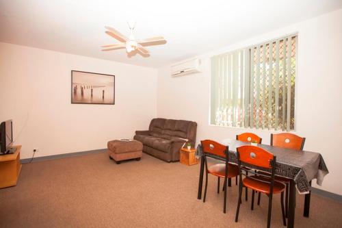a living room with a table and chairs and a couch at Carnarvon Central Apartments in Carnarvon