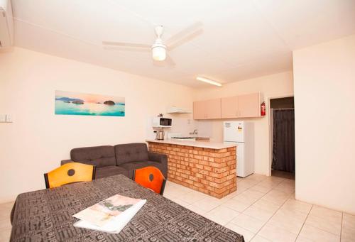 a living room with a couch and a kitchen at Carnarvon Central Apartments in Carnarvon