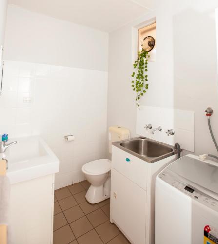 a white bathroom with a sink and a toilet at Carnarvon Central Apartments in Carnarvon