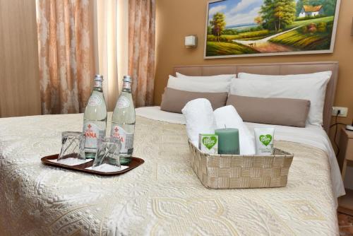 a hotel room with two bottles and two glasses on a bed at Centrum Hotel in Tirana