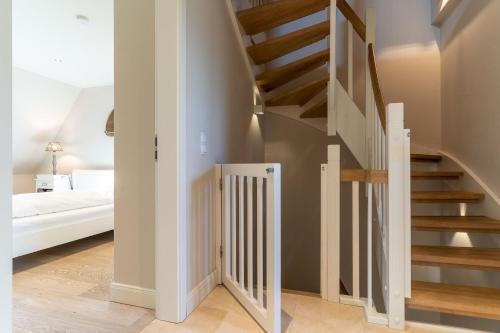 - un escalier en colimaçon dans une chambre avec un lit dans l'établissement Reetdachhaus Dreilanden Reetdachhaus Sünn Hart, à Sankt Peter-Ording