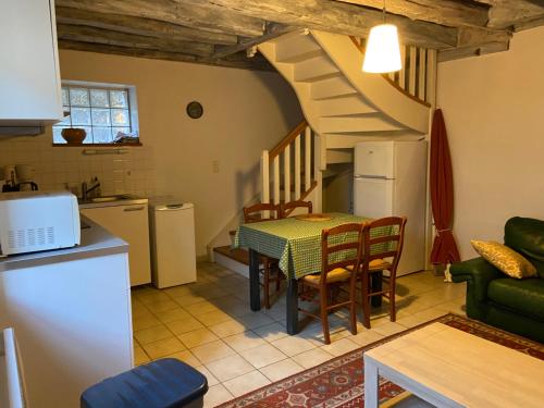 Il comprend une cuisine et un salon avec une table et un escalier. dans l'établissement Gîtes « le clos saint Hilaire », à Mer