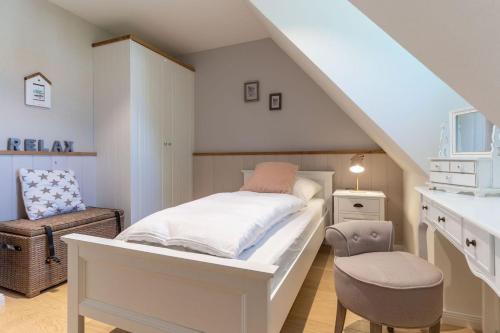 ザンクト・ペーター・オルディングにあるReetdachhaus Unter Reet Reetdachhaus unter Reet IIのベッドと椅子のある白い寝室