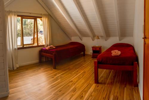 a room with two beds and a window at Cabaña para 4 pax ACCESO BAYO in Villa La Angostura