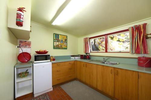 a kitchen with a white refrigerator and a sink at The Berry Farm Retreat in Hastings