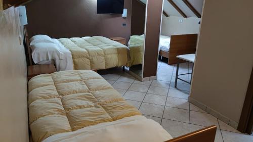 a room with three beds with covers on them at Hotel Emiliana in Villadossola