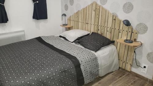ポントルソンにあるLes Fauvettesのベッドルーム1室(木製ヘッドボード付きのベッド1台付)